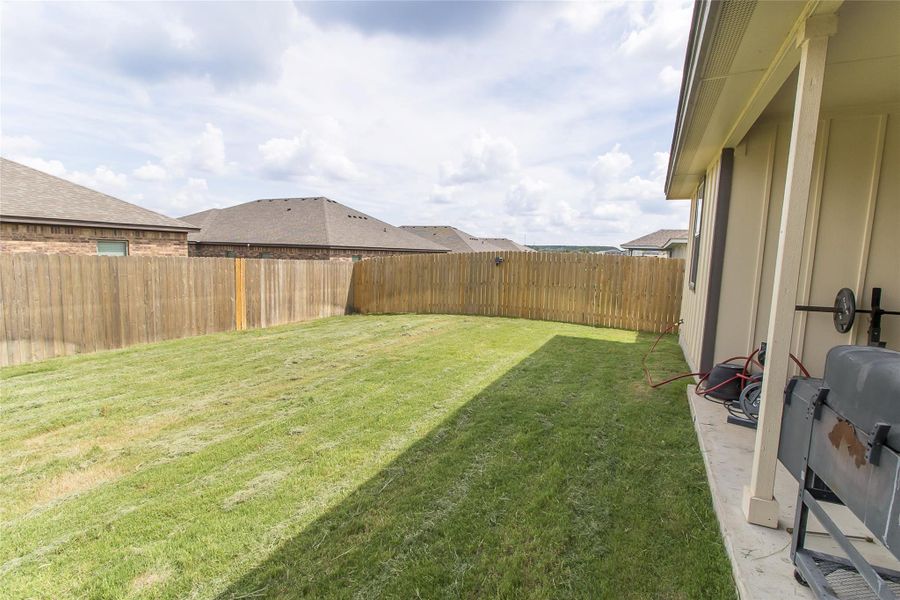 Secure backyard offers ample green space for outdoor activities and private gatherings. Secure backyard offers ample green space for outdoor activities and private gatherings.