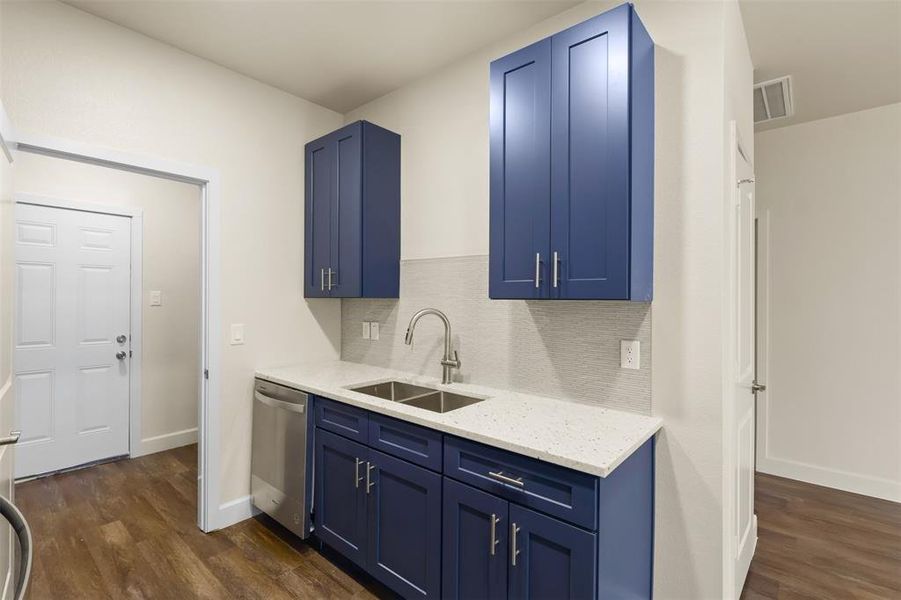 Kitchen featuring sink, dark hardwood / wood-style floors, dishwasher, and blue cabinets