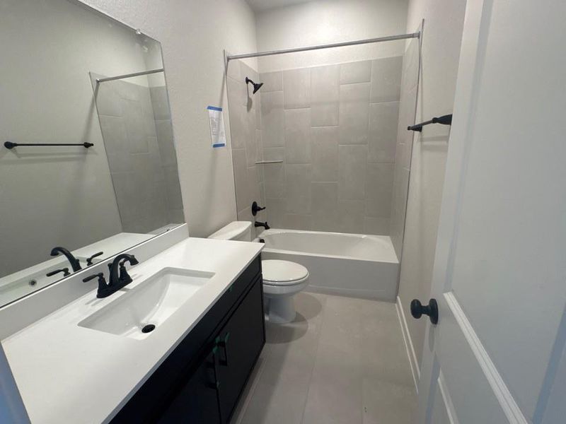 Bathroom featuring shower / bathtub combination, vanity, and light tile patterned floors Bathroom featuring shower / bathtub combination, vanity, and light tile patterned floors