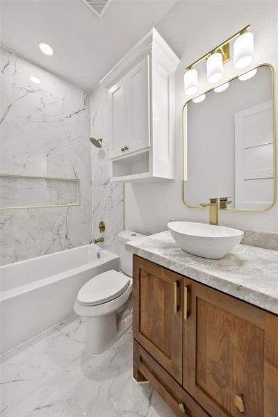 Bathroom featuring a dark wood-finish vanity with a stone countertop, a white vessel sink, and gold-tone fixtures
