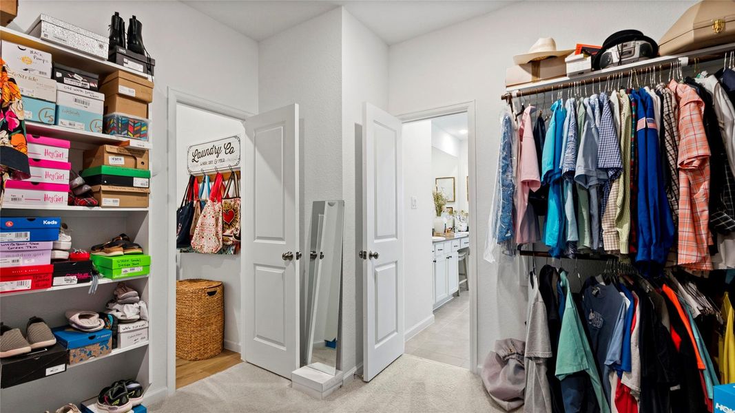 This spacious walk-in closet offers abundant shelving and organized hanging space, plus direct access to the laundry room for added ease and convenience from the primary suite. This spacious walk-in closet offers abundant shelving and organized hanging space, plus direct access to the laundry room for added ease and convenience from the primary suite.