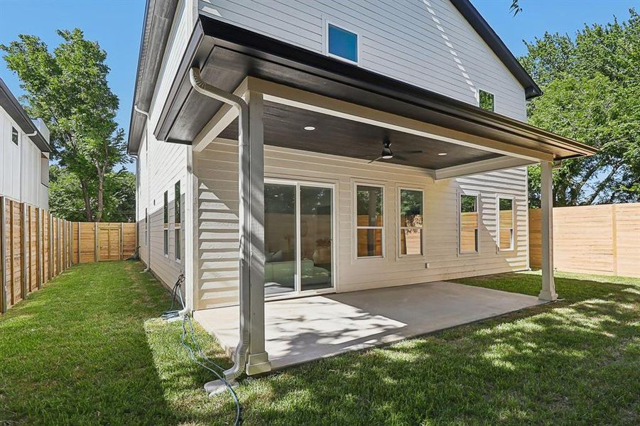 Rear view of house with a ceiling fan, a fenced backyard, and a patio area