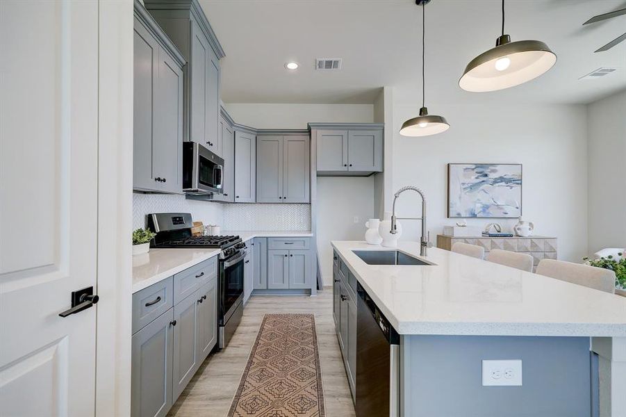 The thoughtfully designed kitchenboasts sleek countertops, amplestorage space, and stainlessappliances.