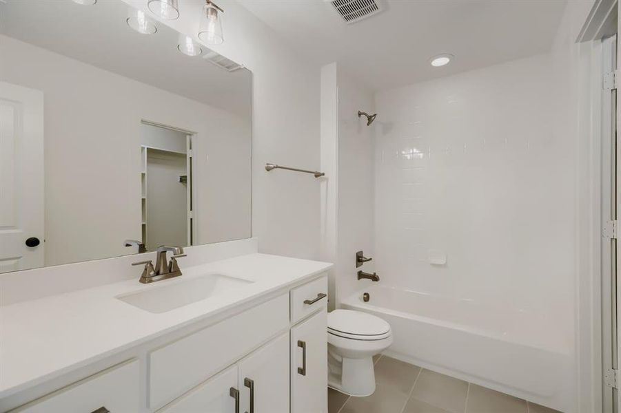 Bathroom featuring a single vanity with a white countertop, brushed nickel faucet, and white cabinetry Bathroom featuring a single vanity with a white countertop, brushed nickel faucet, and white cabinetry