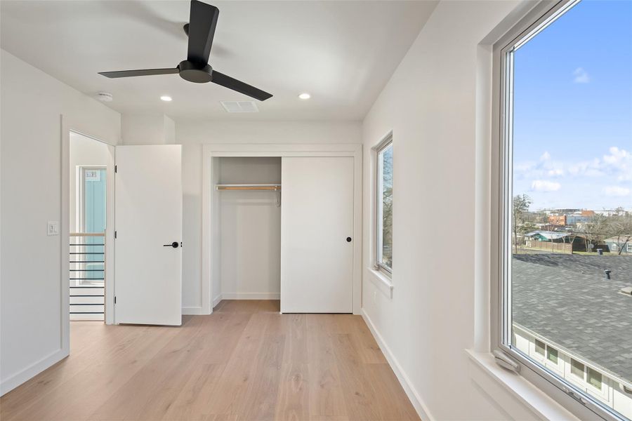 Unfurnished bedroom with light wood-style flooring, visible vents, and baseboards