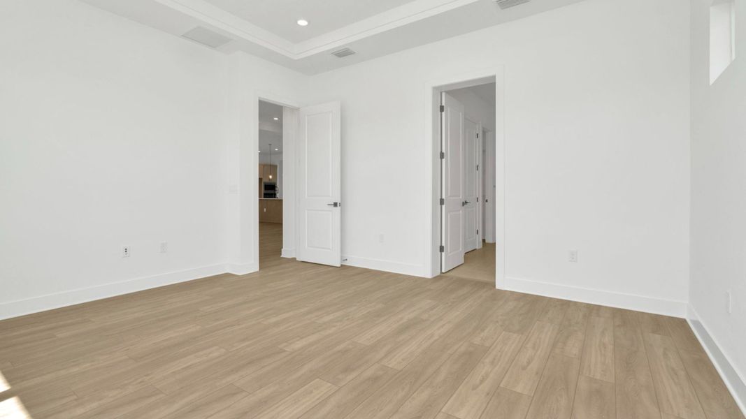 The Primary Bedroom of a DRB Homes Grand Hawk which is offered as a home plan at Serengeti in Spring Hill, FL.