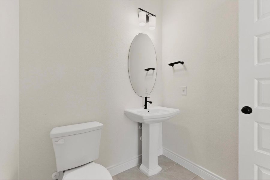 Bathroom with toilet and light tile patterned floors