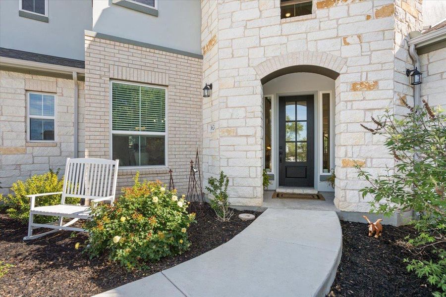 Doorway to property featuring stucco siding and stone siding