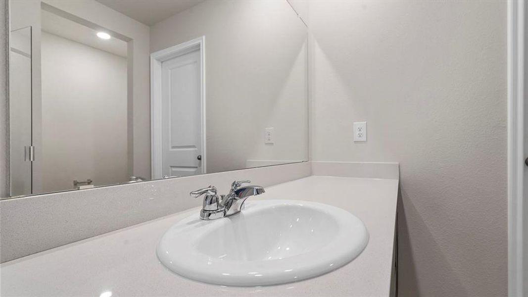 Vanity featuring a white undermount sink with chrome fixtures, a light-toned countertop, and a full-width mirror