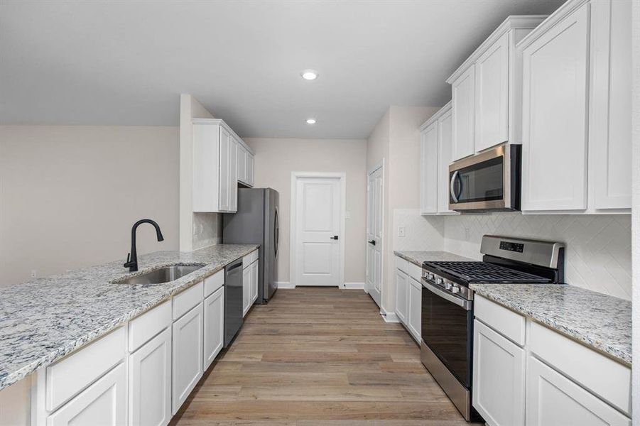 In this kitchen, white cabinets exude a sense of freshness and purity, perfectly paired with the luminous beauty of white granite countertops. The open layout fosters a welcoming atmosphere, inviting conversation and interaction between the kitchen and living area