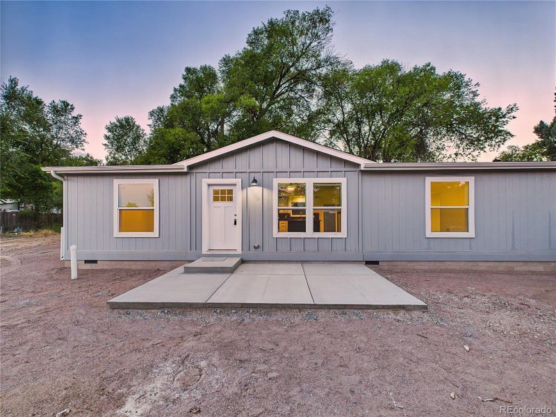Large front concrete patio provides space for outdoor seating.