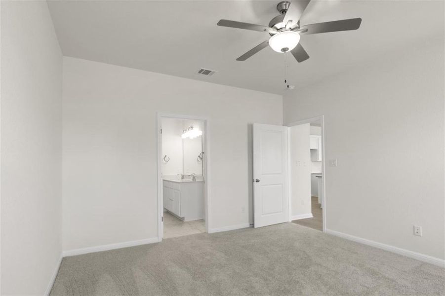 Unfurnished bedroom featuring baseboards, connected bathroom, visible vents, and light colored carpet
