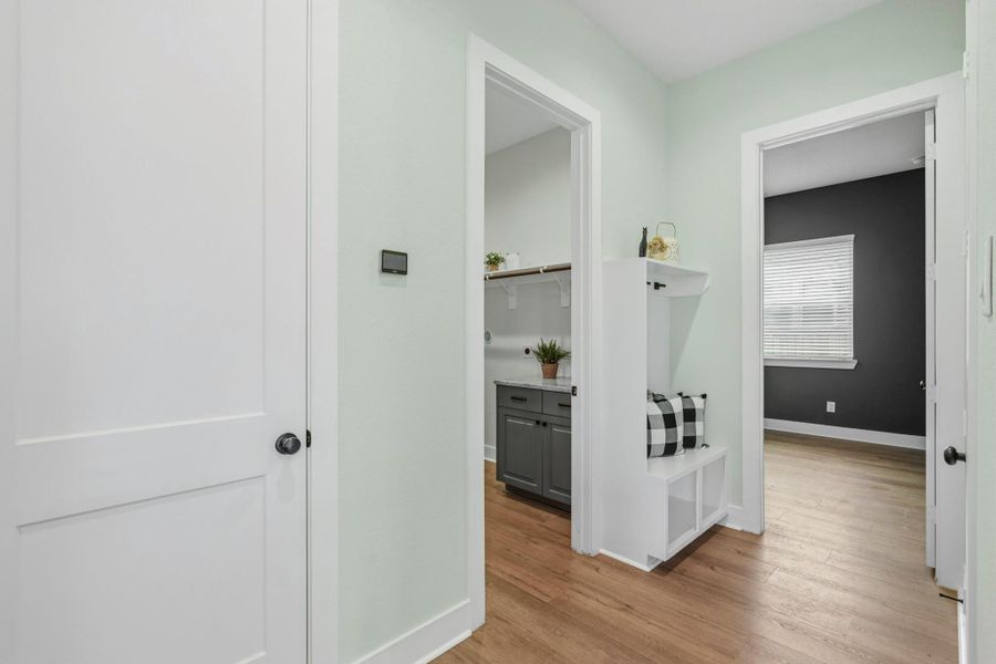 Located off the 2-car Garage sits this well-appointed Mud Room that provides a well curated drop zone for coats, backpacks, and keys. The closed door to the left leads to the Garage, followed by the Laundry Room, and then the Media Room.