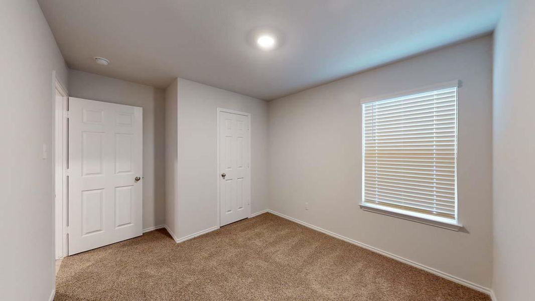 Carpeted room featuring light gray painted walls, a white window with horizontal blinds, and two white paneled doors