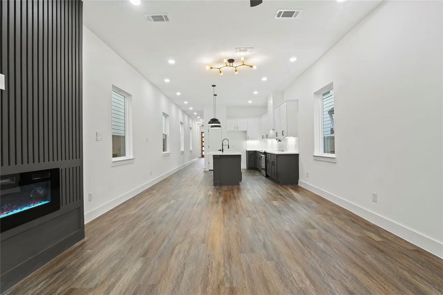Unfurnished living room featuring dark wood-style floors and recessed lighting