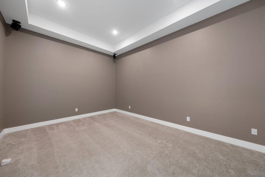 This media room is the perfect spot for movie nights or gaming sessions, with plush carpeting and built-in surround sound speakers for an immersive experience. This media room is the perfect spot for movie nights or gaming sessions, with plush carpeting and built-in surround sound speakers for an immersive experience.