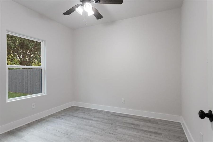 Unfurnished room with light hardwood / wood-style floors and ceiling fan