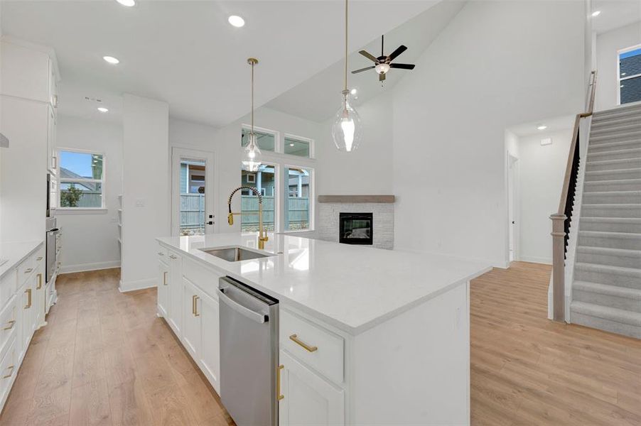 Open concept living area featuring a kitchen with a large island, stainless steel appliances, and a gold-toned faucet