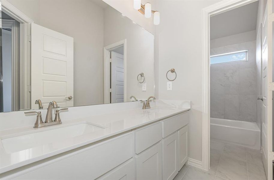 Bathroom with double vanity and shower / bath combination