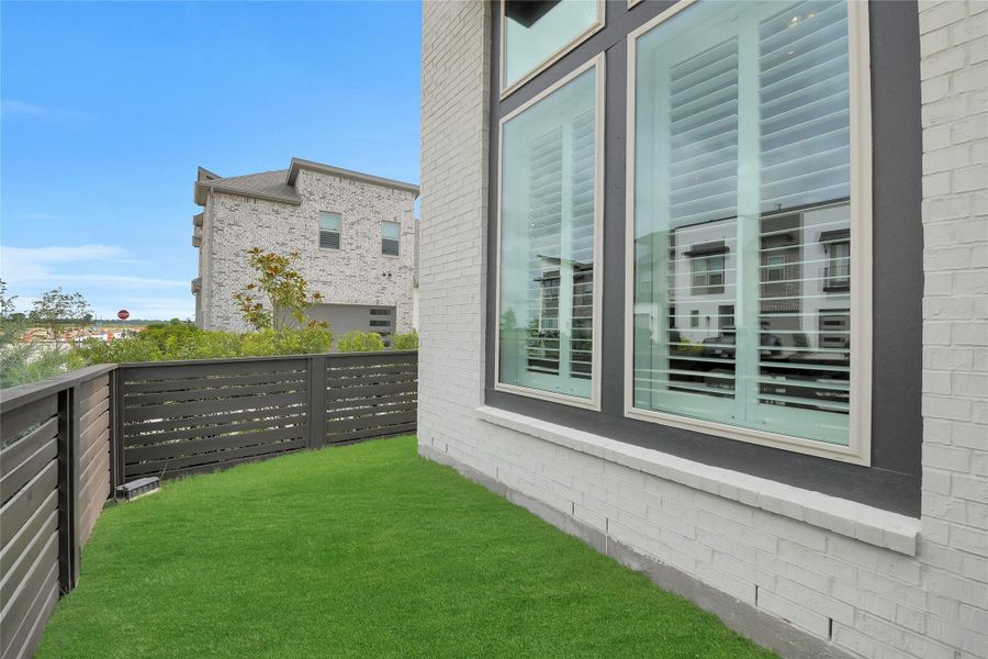 View of the yard area to the left of the front walkway. This end unit offers good space for pets.