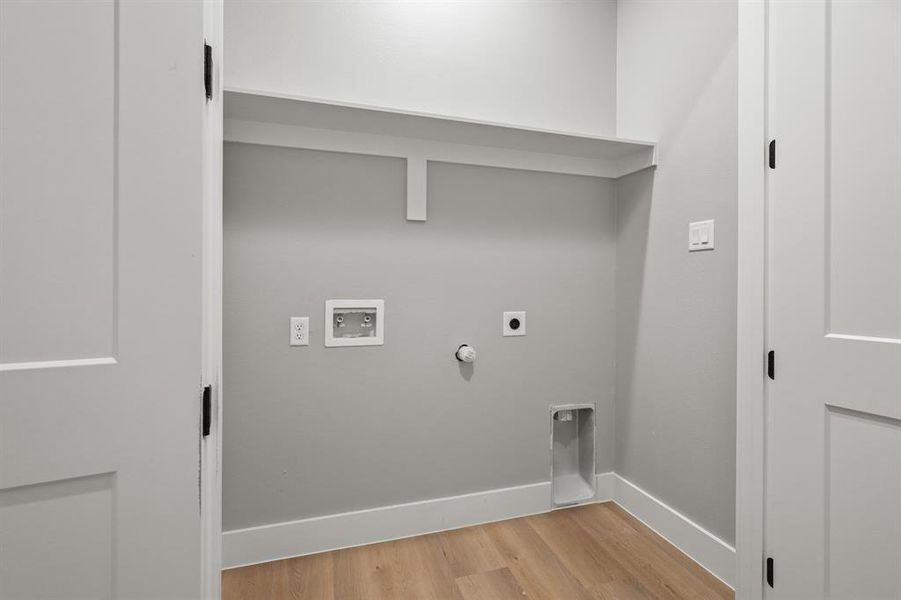 Laundry area with hookup for a gas dryer, hookup for a washing machine, light hardwood / wood-style flooring, and hookup for an electric dryer