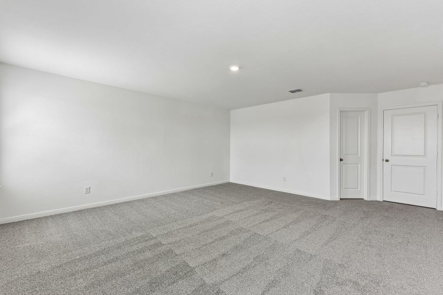 Spacious room featuring light gray carpet flooring and bright white walls