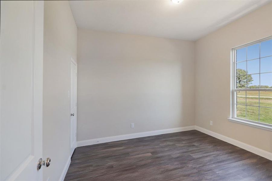 Empty room featuring dark wood-type flooring