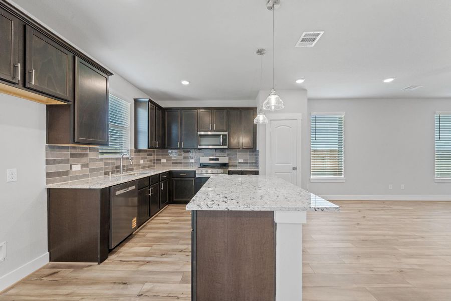 This beautiful open concept kitchen boasts stunning cabinetry that stretches to the ceiling, and pantry offering both style and ample storage. This beautiful open concept kitchen boasts stunning cabinetry that stretches to the ceiling, and pantry offering both style and ample storage.
