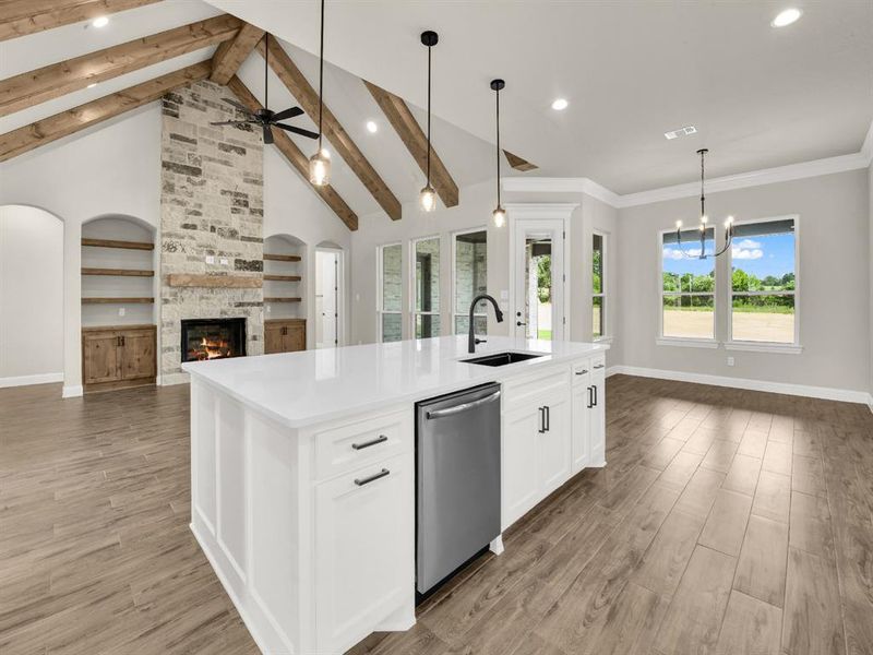 Kitchen with a sink, dishwasher, open floor plan, baseboards, and a fireplace Kitchen with a sink, dishwasher, open floor plan, baseboards, and a fireplace