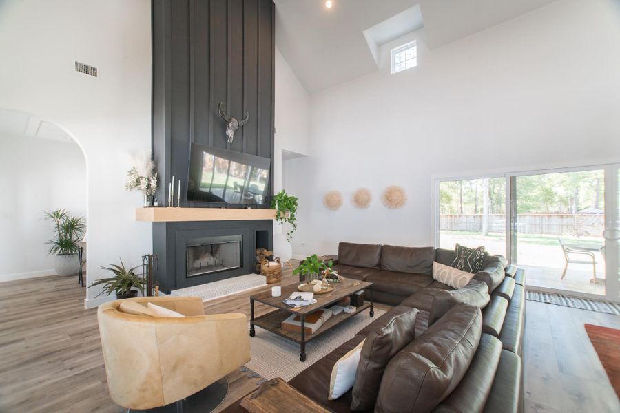 Another view of the living room, showcasing the impressive, ceiling-height fireplace Another view of the living room, showcasing the impressive, ceiling-height fireplace