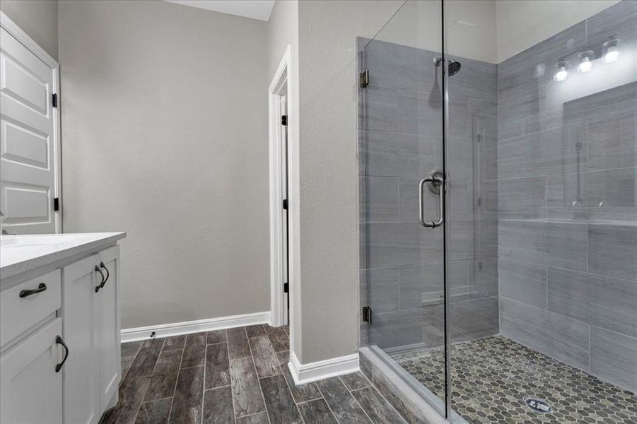Full bathroom featuring vanity, wood tiled floors, and a stall shower