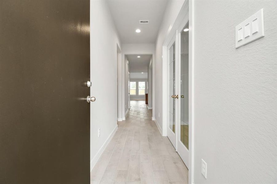 As you step into the threshold of this luxurious home, you'll soon be welcomed by an elegant glass door (to be installed), high ceilings, adorned with elegant wood-look tile flooring and oversized baseboards, and recessed lighting. Follow path of natural light from expansive windows ahead. Example photo of completed home with similar plan. Actual may vary.