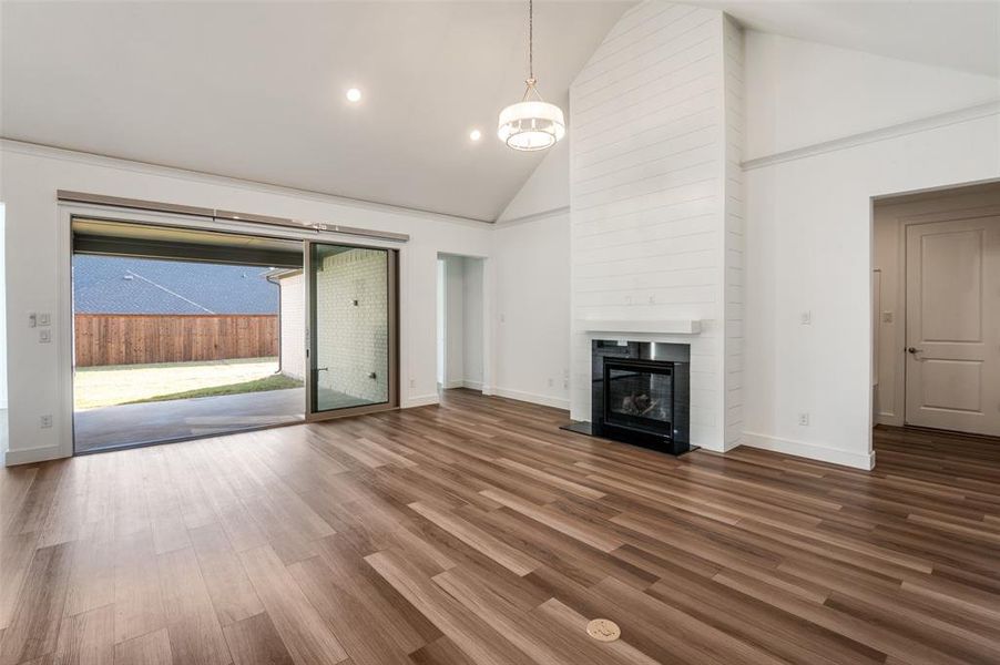 Large living room with high vaulted ceiling, dark wood-style floors, a fireplace, and recessed lighting Large living room with high vaulted ceiling, dark wood-style floors, a fireplace, and recessed lighting