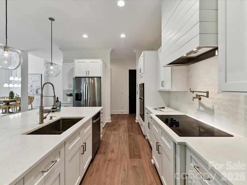 Kitchen also features subway tile backsplash, pot filler, and a spacious island designed for both cooking and entertaining.
