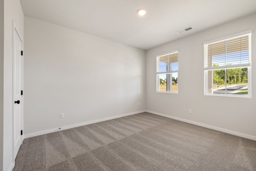 A room with windows and a carpet.