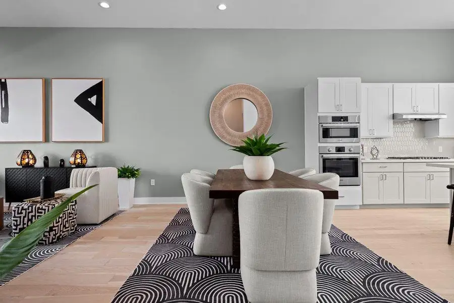 Smooth wood floors anchor this open concept dining space bordering a modern kitchen. Smooth wood floors anchor this open concept dining space bordering a modern kitchen.