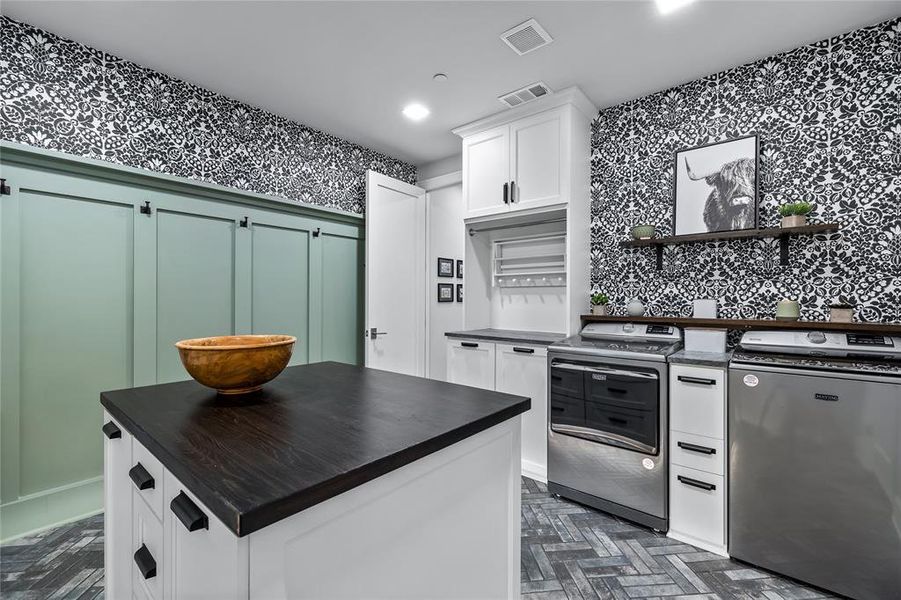 Kitchen featuring white cabinetry, stainless steel electric range oven, a center island, dark parquet floors, and refrigerator