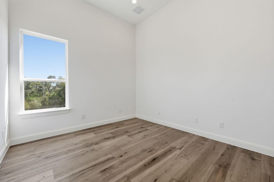 Empty room featuring light wood-type flooring and recessed lighting