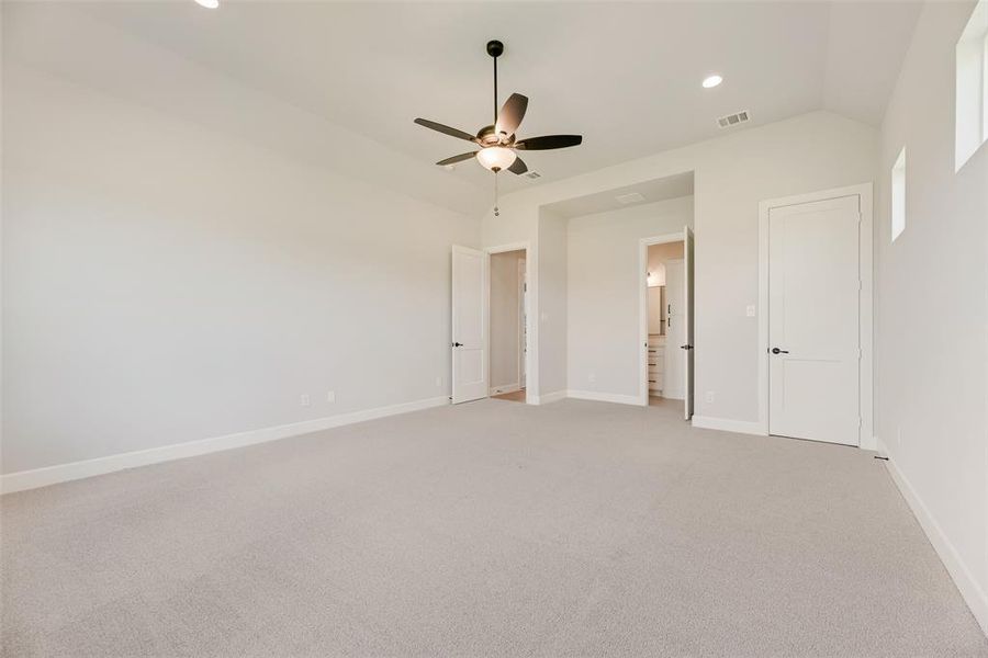 Unfurnished bedroom featuring light colored carpet, recessed lighting, ensuite bath, and a ceiling fan