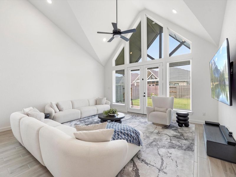 This family room will impress all with it unique architectural features and a cathedral ceiling. The wall of windows let in the light, but its protected from the heat by the extended covered patio. This family room will impress all with it unique architectural features and a cathedral ceiling. The wall of windows let in the light, but its protected from the heat by the extended covered patio.