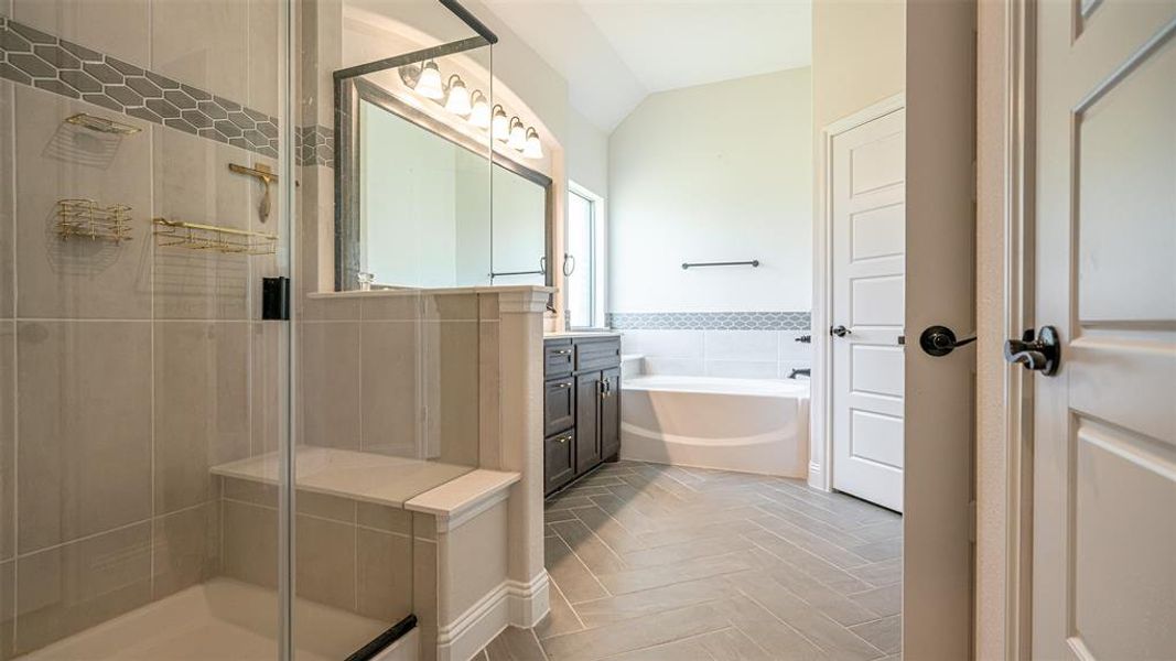 Shower with glass enclosure, built-in bench, and hexagon tile accent