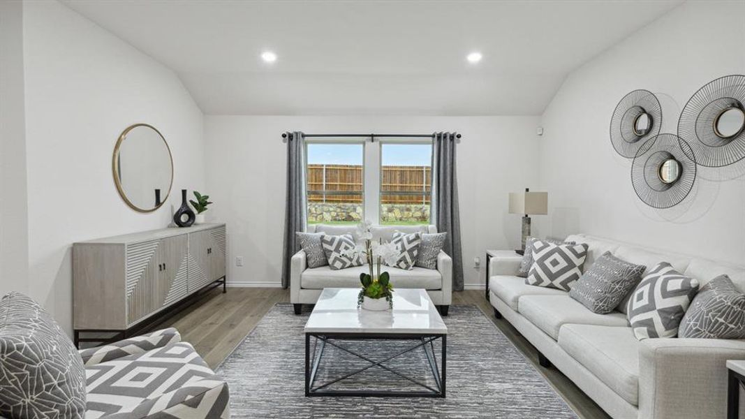Living room featuring lofted ceiling, wood finished floors, and recessed lighting Living room featuring lofted ceiling, wood finished floors, and recessed lighting