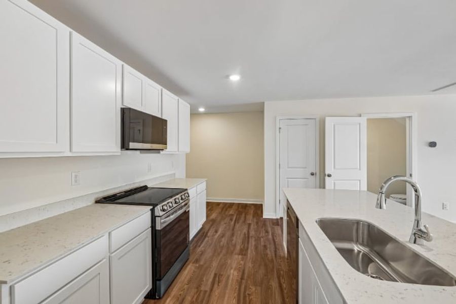 A kitchen with white cabinets.