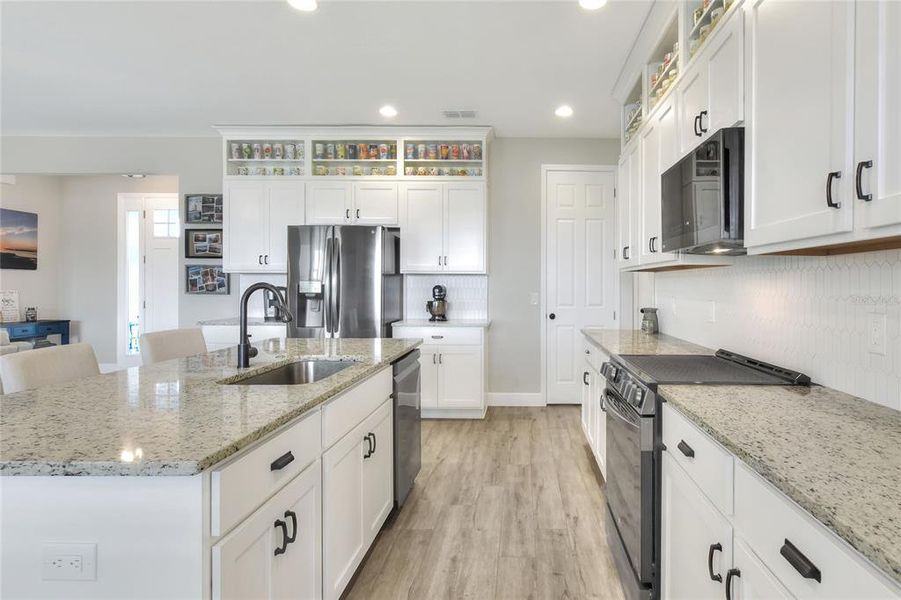 Kitchen with custom cabinetry and island seating.