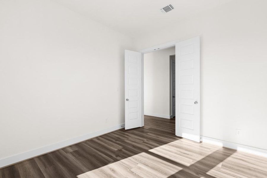 Empty room with baseboards and dark wood-style flooring Empty room with baseboards and dark wood-style flooring