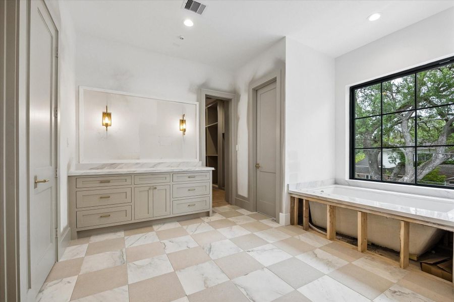 Primary bathroom featuring separate water closets, soaking tub and separate vanities. Pictured April 2026.