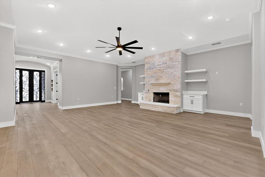 Living room with wood flooring, a fireplace, crown molding, a ceiling fan, and recessed lighting, Front Door on the left side Living room with wood flooring, a fireplace, crown molding, a ceiling fan, and recessed lighting, Front Door on the left side