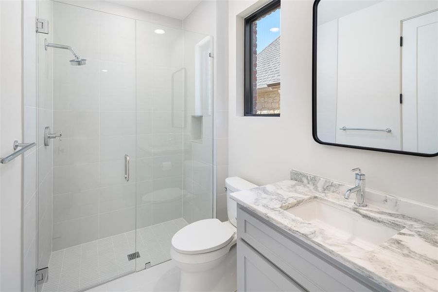 Bathroom with vanity, an enclosed shower, and toilet