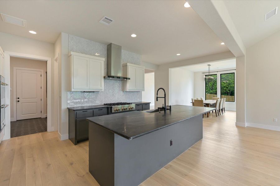 A contemporary kitchen features a spacious island with sink, perfect for culinary endeavors and casual dining.