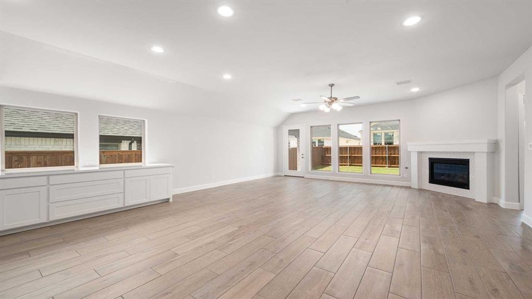 Unfurnished living room with ceiling fan and light hardwood / wood-style floors